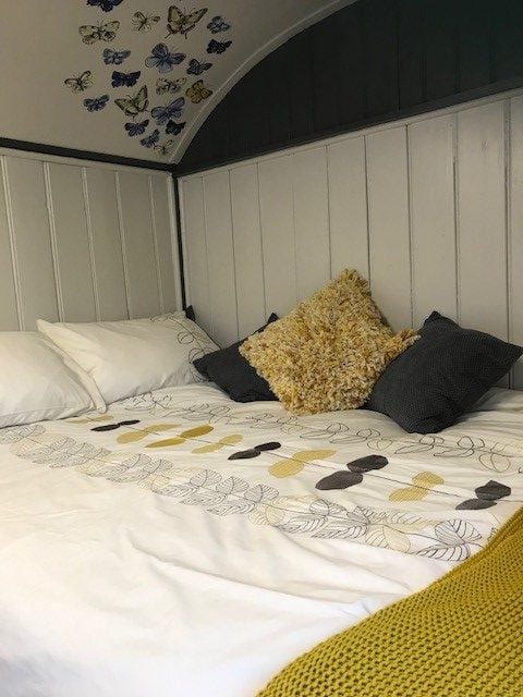 Soft bed linen and cushions inside Mabel’s timber-lined interior